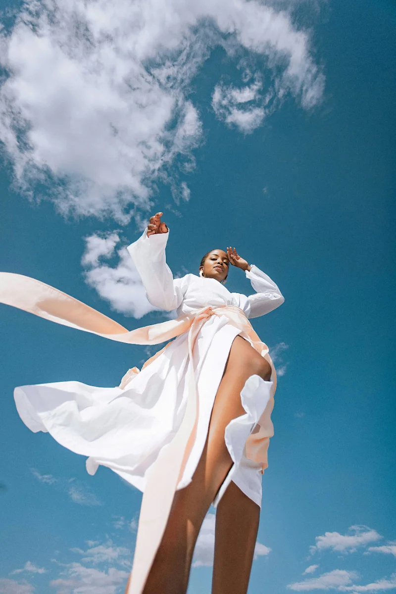 Woman in white against a bright sky